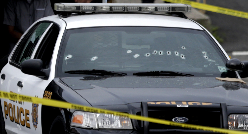 A Jersey City Police Department cruiser is seen with bullet holes on the windshield at the scene where an officer was shot and killed while responding to a call at a 24-hour pharmacy on Sunday in Jersey City, N.J.  Officer Melvin Santiago was shot in the head while still in his police vehicle.