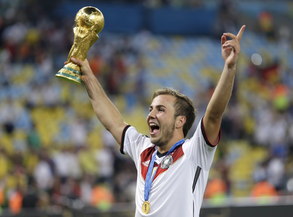 Germany’s Mario Goetze, who scored the winning goal, holds the World Cup trophy following a 1-0 victory over Argentina in the championship game Sunday at the Maracana Stadium in Rio de Janeiro, Brazil.