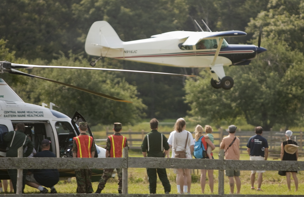 People watch a single-engine plane land Sunday at Sprague Field in Cape Elizabeth.