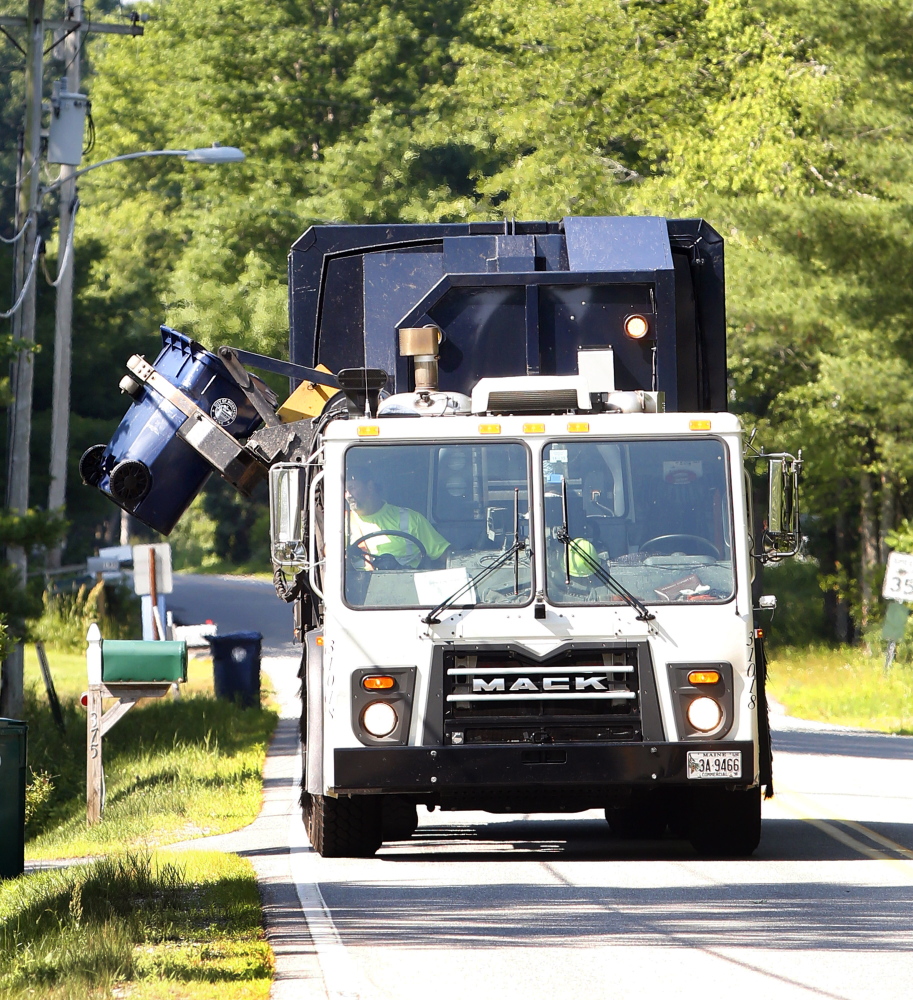A Pine Tree Waste Services recycling truck empties a container Tuesday in Biddeford. The city of Biddeford has completed its first year of curbside recycling and saved more than $200,000 in trash disposal fees.