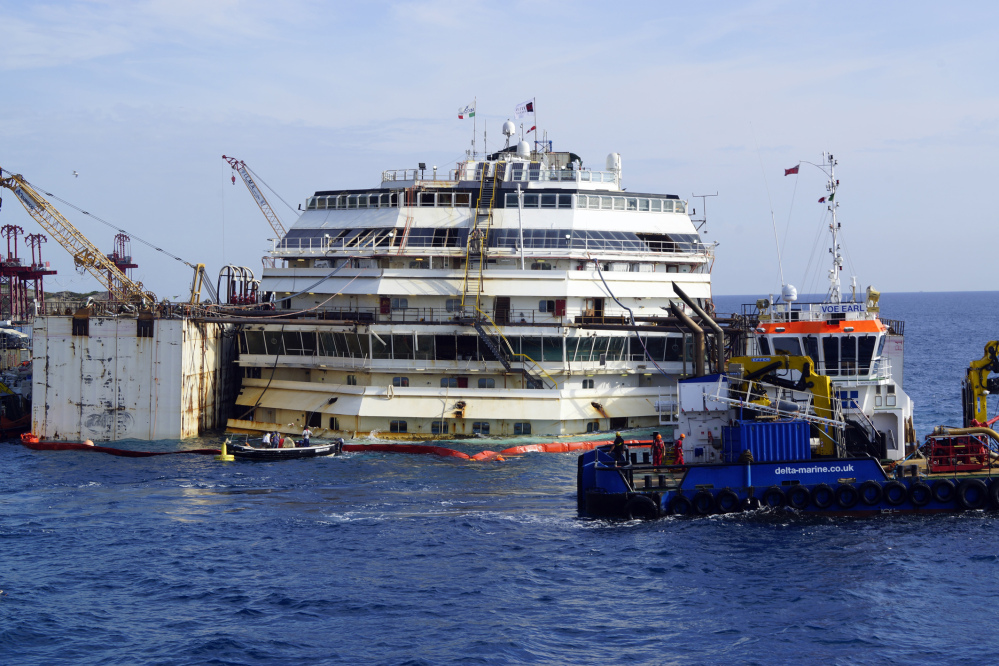 Workers carry on the operations on the luxury cruise ship Costa Concordia, to put put it afloat, on the tiny Tuscan island of Giglio, Italy on Monday. The shipwrecked Costa Concordia has been successfully put afloat in preparation to tow it away for scrapping.