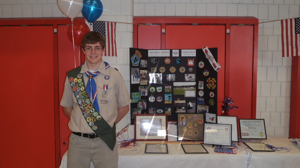 Jacob Rioux, who recently attained the rank of Eagle Scout, stands in front of his Eagle display board showing his Scouting achievements, including letters of commendation from President Barack Obama and Gov. Paul LePage.