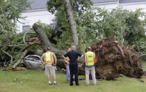 YORK, ME - JULY 16: Public works employees and a York police officer look over damage next to the First Parish Church after a severe storm hit York, Maine. (Photo by John Patriquin/Staff Photographer)
