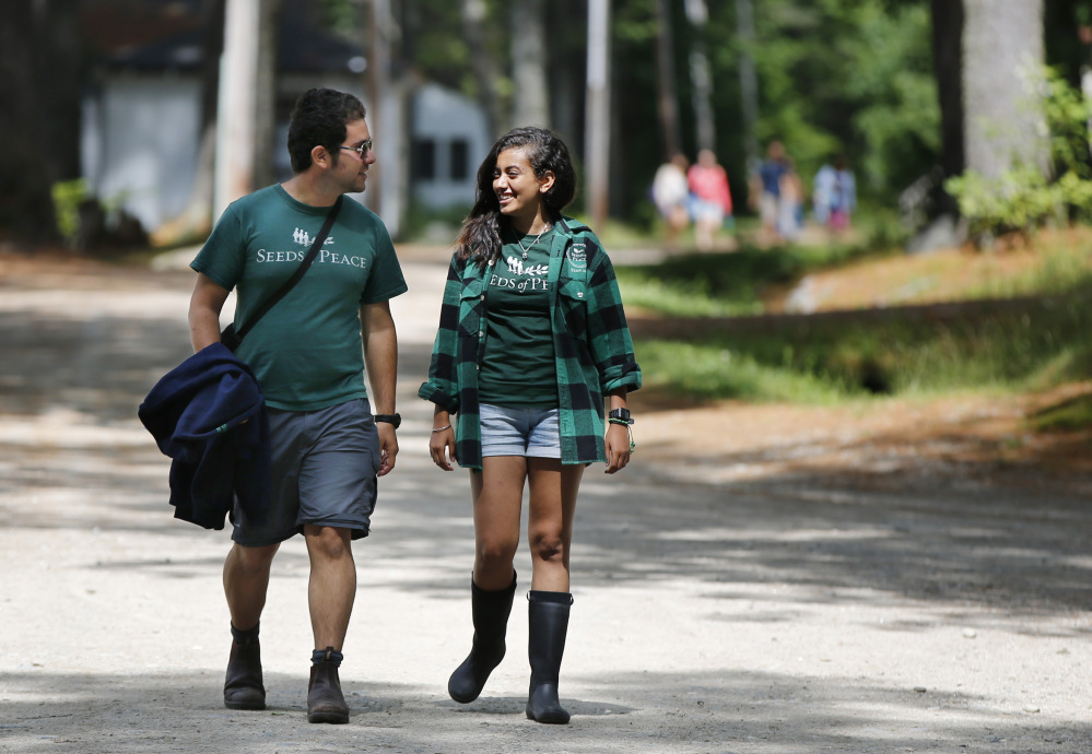Camp counselors Hagai Dfrat, 23, of Israel, left, and Monica Baky of Egypt talk while walking on the grounds of the Seeds of Peace camp in Otisfield.