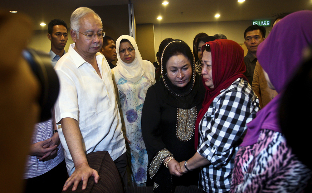 Malaysian Prime Minister Najib Razak, left, and his wife Rosmah Mansor, center in black, meet family members of the passengers on board Malaysia Airlines MH 17, at a hotel in Putrajaya, Malaysia, on Saturday. Malaysia’s transport minister said the country is “deeply concerned” that the site in Ukraine where the Malaysia Airlines jetliner was shot down with 298 people onboard “has not been properly secured.”