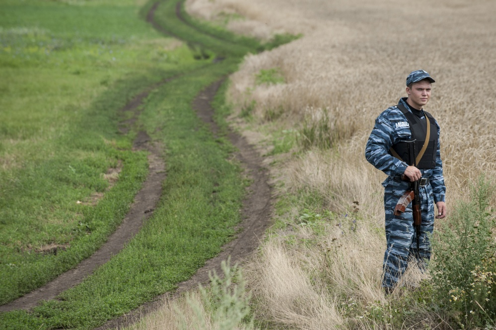 A pro-Russian fighter stands in a field at the crash site of a Malaysia Airlines jet near the village of Hrabove, eastern Ukraine, on Saturday.