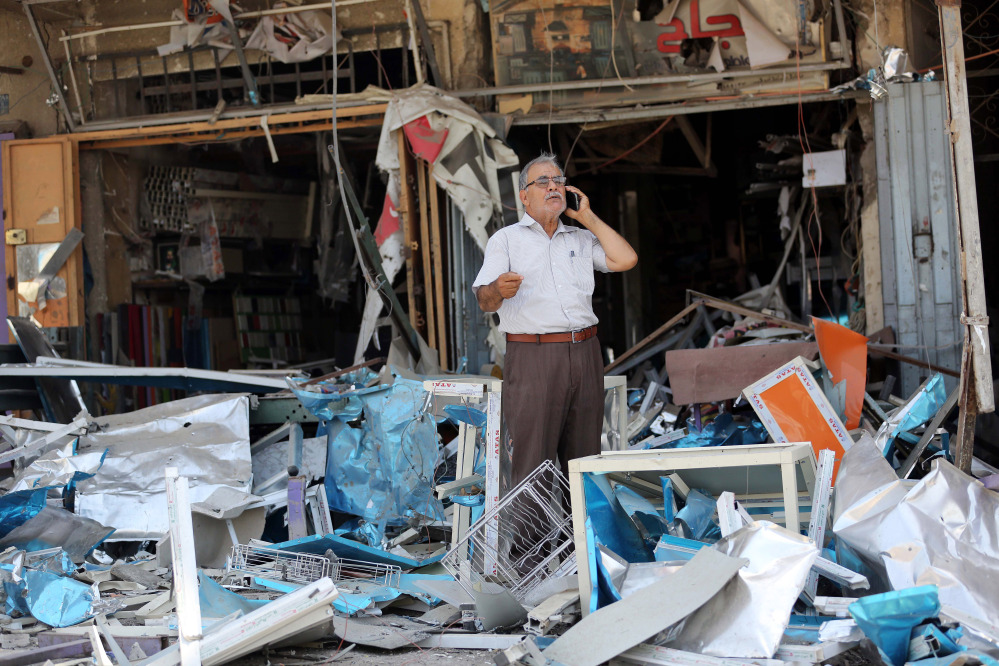 An Iraqi man inspects the site of a bomb attack in the Jihad district in Baghdad on Saturday.
