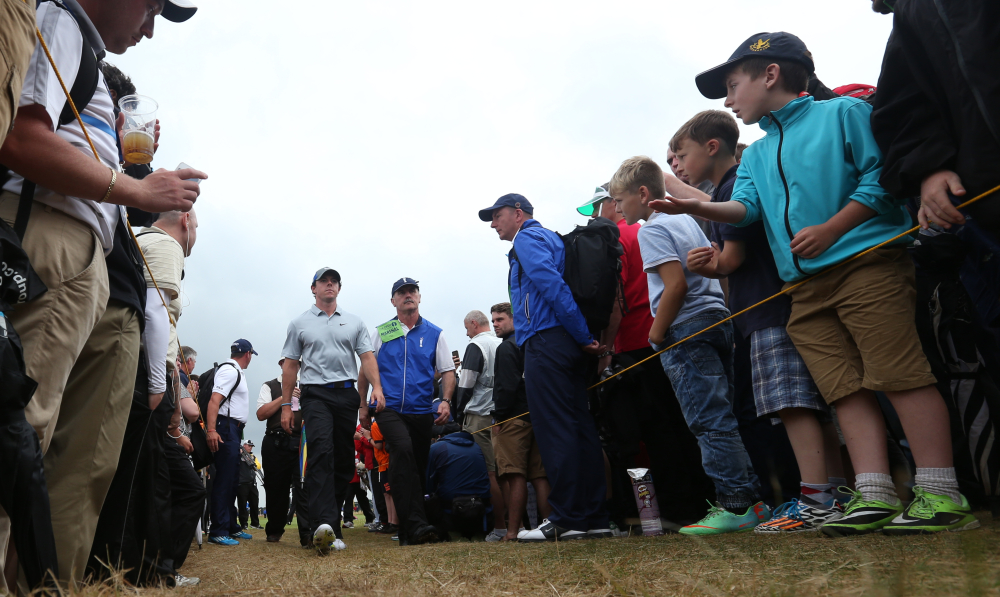 Rory McIlroy walks past fans on his way to the 18th tee box Saturday at the British Open in Hoylake, England. McIlroy shot a 4-under 68 to maintain a 6-shot overall lead.