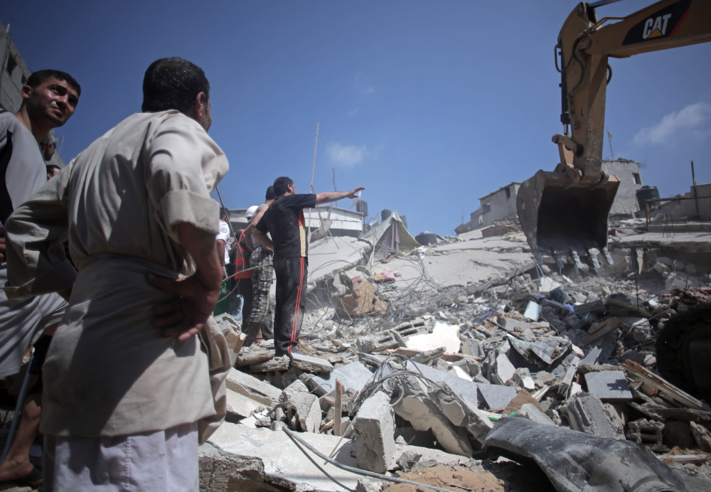 Palestinian rescuers search for bodies and survivors in the rubble of homes that were destroyed by an Israeli missile strike, in Gaza City on Monday.