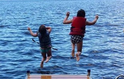 Photo courtesy of Allicia Rogers Golden 
 Emerson, left, and Charlie Golden, of Solon, jump off the dock at their family's camp on Embden Lake recently.