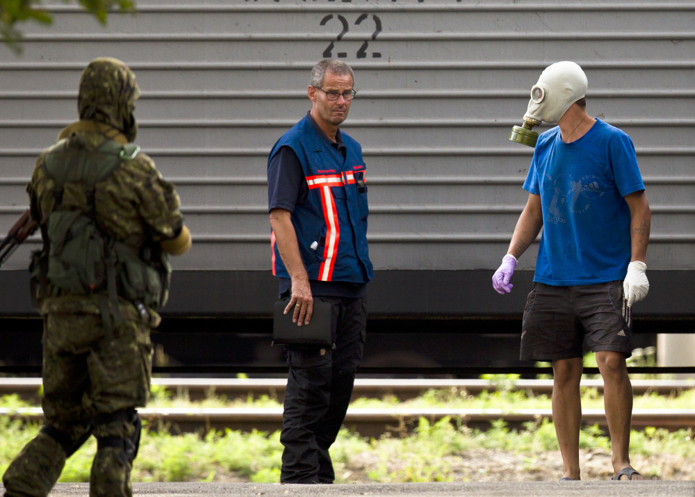 Peter Van Vilet, center, team leader of Holland’s National Forensic Investigations Team, stands on the platform after observing the loading of newly retrieved bodies of passengers on a refrigerated train in Torez, eastern Ukraine, 9 miles from  the crash site of Malaysia Airlines Flight 17, on Monday.