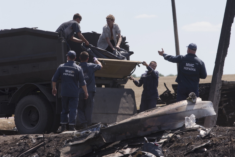 Forensic experts load remains of victims of the Malaysian Airlines plane crash at Hrabove, Donetsk region, eastern Ukraine, on Monday. Outrage over the delays and the possible tampering of evidence at the site was building worldwide.