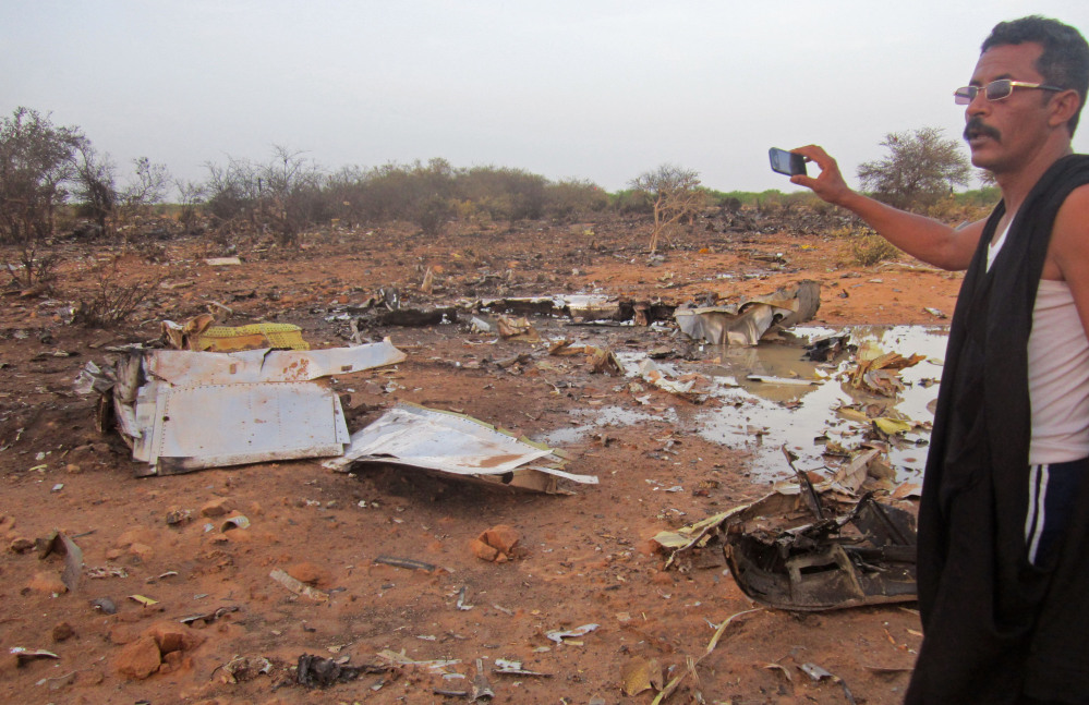 This photo provided by the Burkina Faso Military shows a man at the site of the Air Algerie plane crash in Mali. At least 116 people were killed in Thursday’s disaster, nearly half of whom were French.