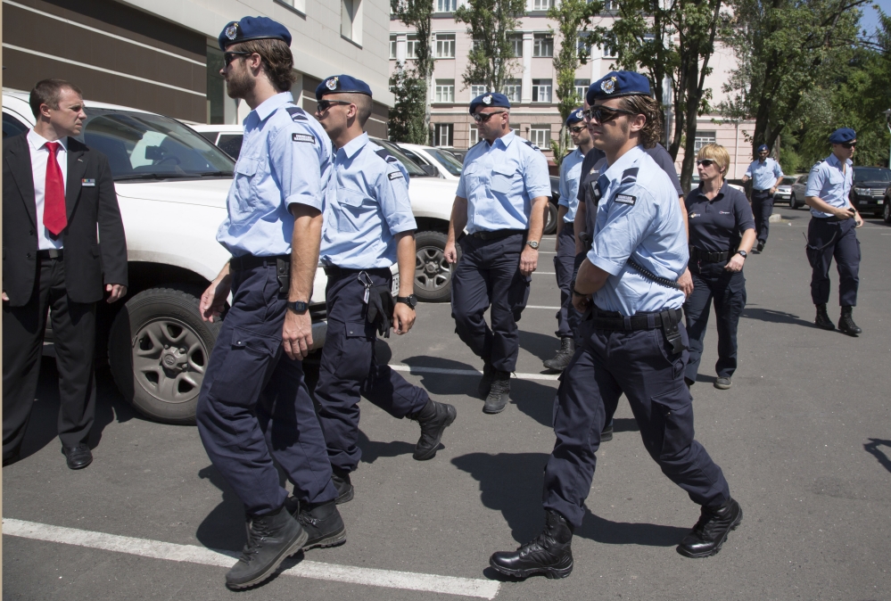 Dutch policemen walk in the city of Donetsk, eastern Ukraine Sunday.