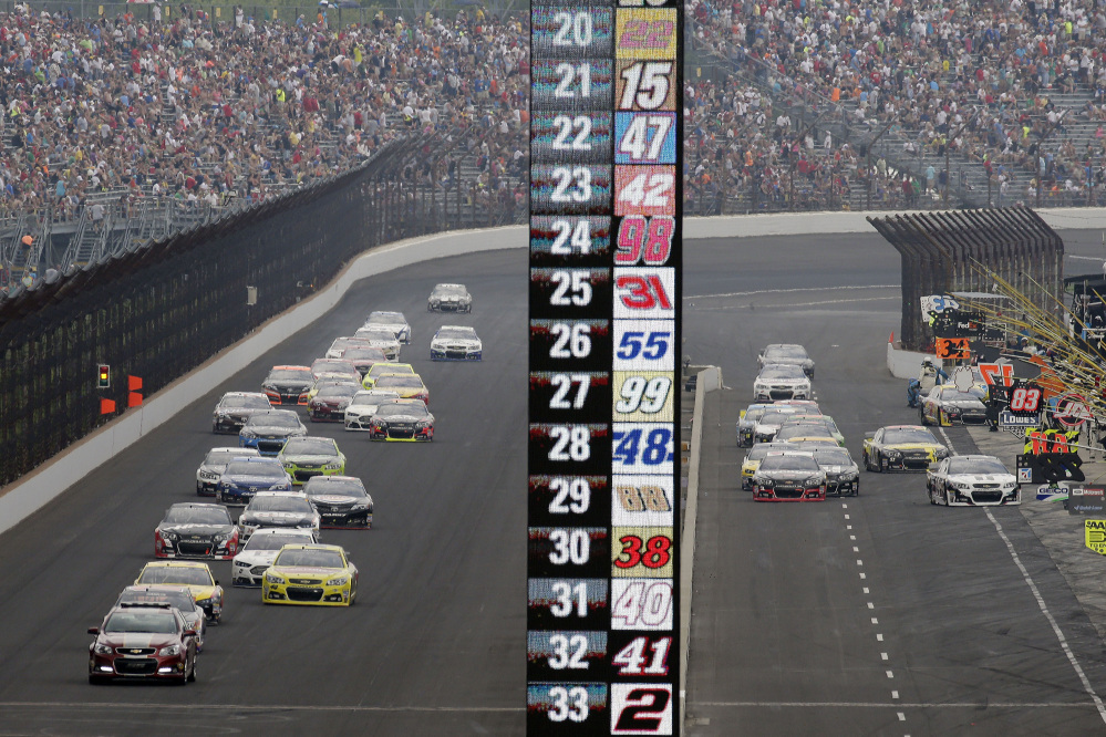 Cars on different pit strategies enter pit lane while others stay on the track in a caution period during the NASCAR Brickyard 400 auto race at Indianapolis Motor Speedway in Indianapolis, Sunday.