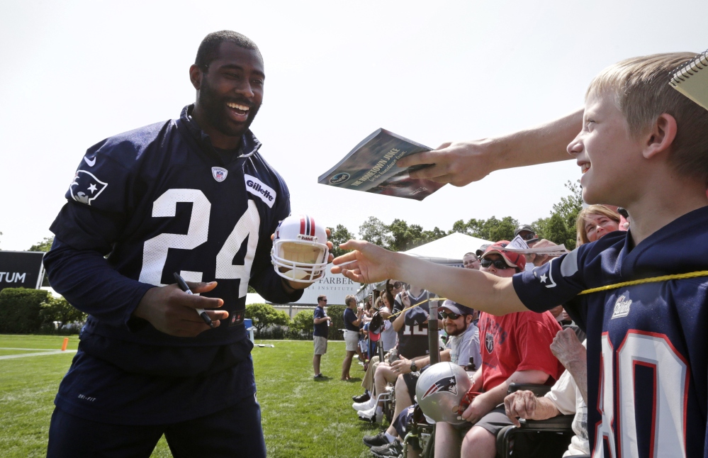New England Patriots cornerback Darrelle Revis jokes with fans as he signs autographs after training camp Friday in Foxborough, Mass.