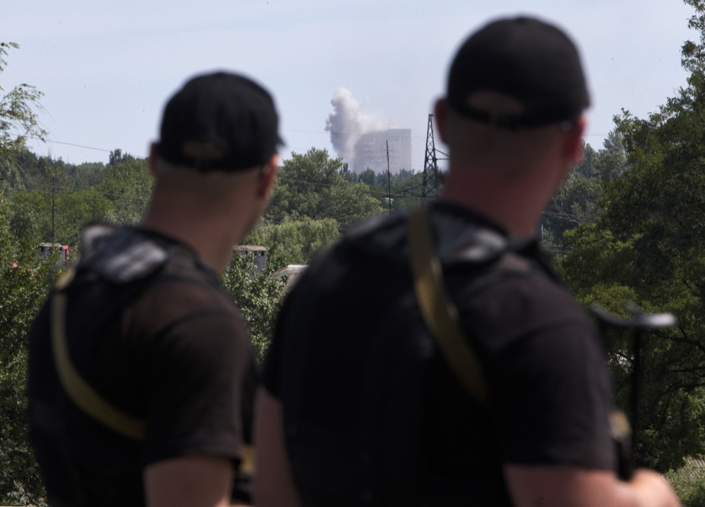 Self-proclamed Donetsk People’s Republic policemen watch shelling in Shakhtarsk, Donetsk region, eastern Ukraine on Monday.