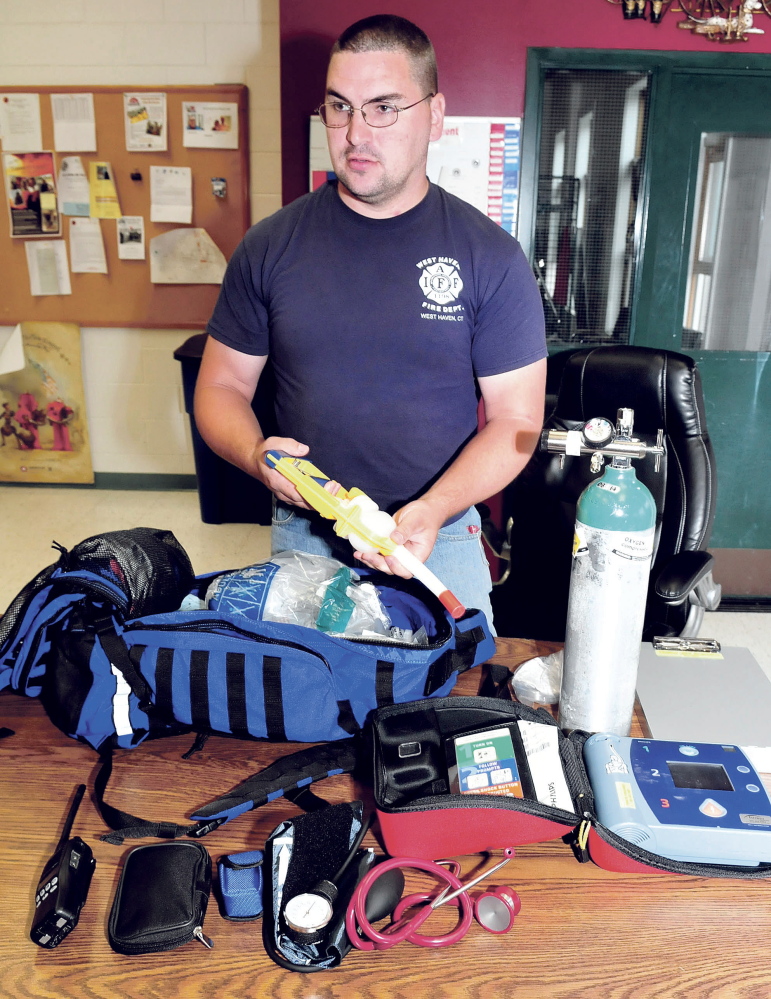 Dan Mayotte, a Waterville firefighter and an organizer of the Vassalboro First Responders group, shows the medical equipment he carries in his pack to people who need help.