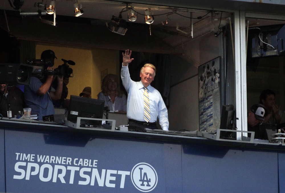 Broadcaster Vin Scully acknowledges the crowd at Dodger Stadium during a baseball game between the Los Angeles Dodgers and the Atlanta Braves on Tuesday.
