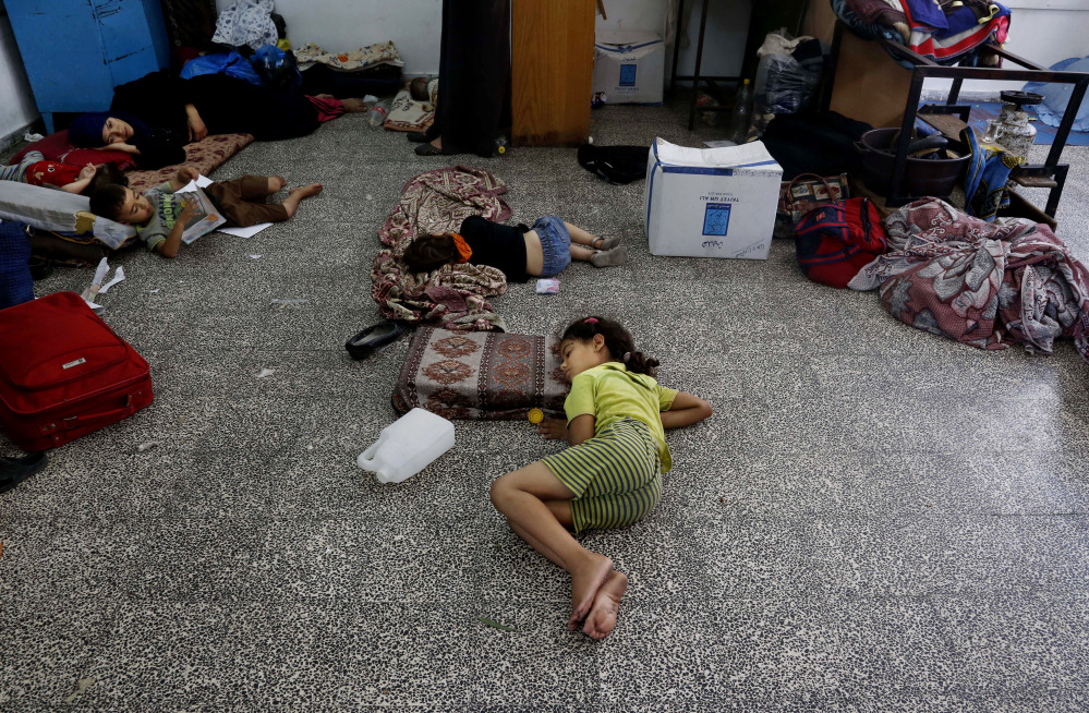 Palestinian children lay on the floor at the Abu Hussein U.N. school, hit by an Israeli strike earlier, in the Jebaliya refugee camp, northern Gaza Strip, Wednesday. Israeli tank shells slammed into a crowded U.N. school sheltering Gazans displaced by fighting on Wednesday, killing more than a dozen and wounding tens after tearing through the walls of two classrooms, a spokesman for a U.N. aid agency and a health official said.
