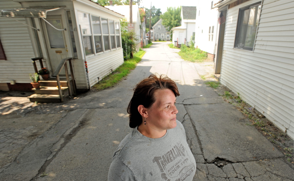 Betty Hovey, 40, stands on Carey Lane on Friday. A man was stabbed at a house on the street earlier in the week.