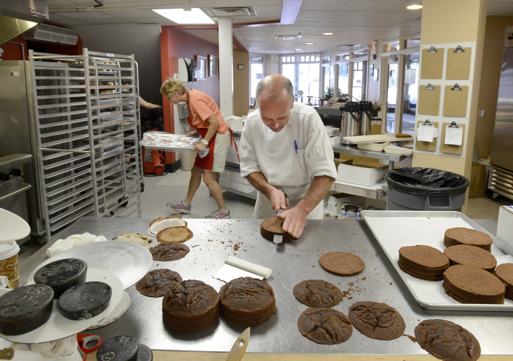 Ed Foley makes chocolate mousse cakes as Molly Foley places a tray into a rack at their bakery in Monument Square in Portland. They have sold their bakery business to baker Andrea Swanson.