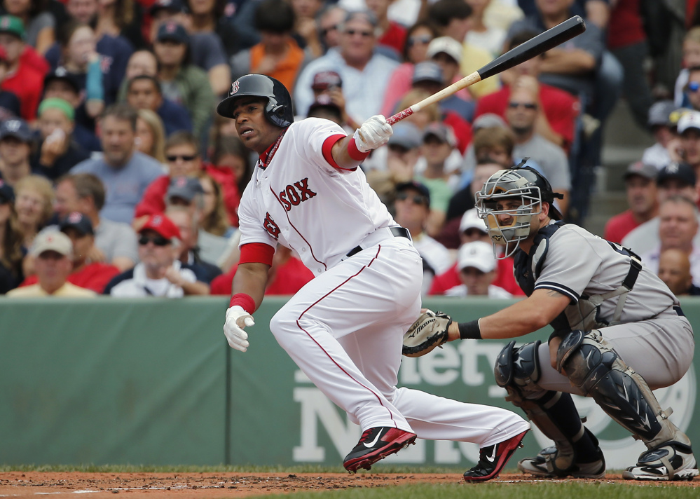 Boston’s Yoenis Cespedes follows through on a single in his first at-bat as a Red Sox player, as New York Yankees catcher Francisco Cervelli watches during the second inning Saturday at Fenway Park in Boston. Cespedes went 1 for 4 with a single.