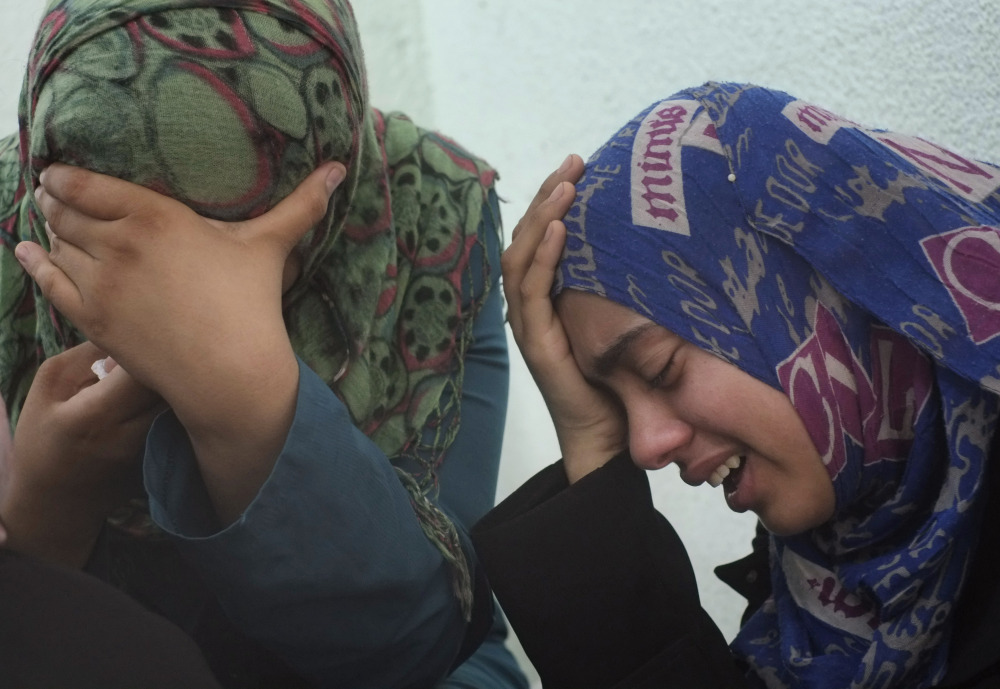 Palestinian relatives of the Abu Wahdan family cry outside the morgue of the Kamal Adwan hospital in Beit Lahiya after the bodies of three members of the family, that were killed in an overnight Israeli strike, were taken away for their funeral on Sunday. Jamila, 55, Hatem, 57, and Sanwara Abu Wahdan , 27, were killed at the hit, after the extended family of more than 40 people had sought refuge in Jebaliya from shelling elsewhere.