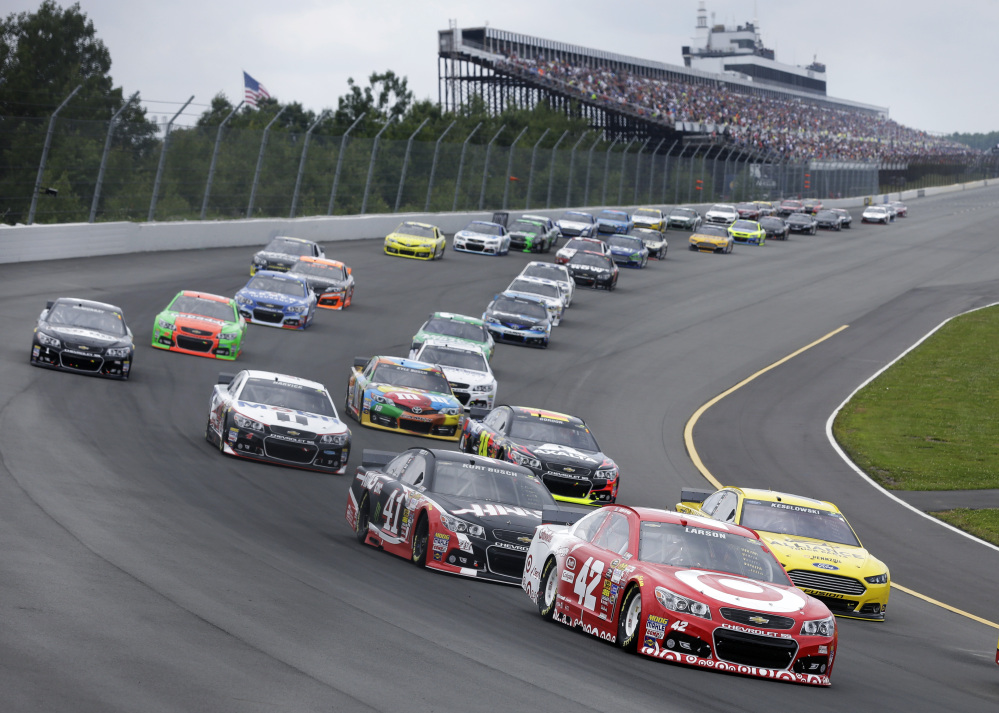 Kyle Larson (42) leads a pack of cars at the start of the NASCAR Sprint Cup Series auto race at Pocono Raceway, Sunday, Long Pond, Pa.