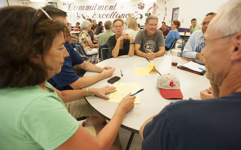 Ann Mitchell of Ward 2 signs nomination papers during the Waterville Democratic caucus at Waterville High School on Sunday.