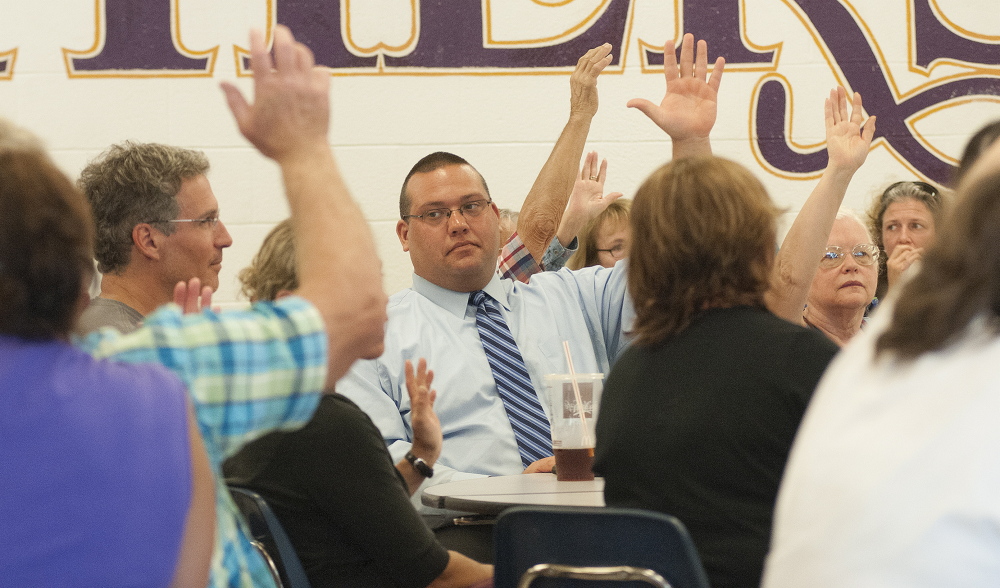 Members of Ward 2 vote with a show of hands during the Waterville Democratic caucus at Waterville Senior High School on Sunday.