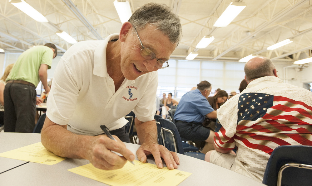 Steve Aucoin fills out paperwork after being nominated to run for mayor during the Waterville Democratic caucus at Waterville Senior High School on Sunday.