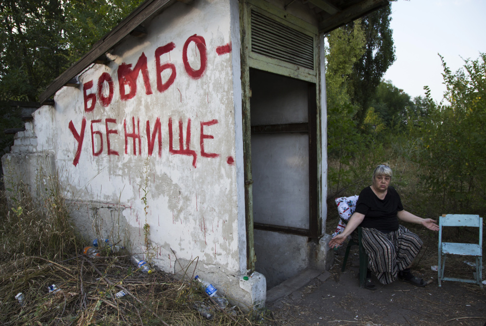 Local resident Galina Dudkina gestures near to an entrance with “Bomb Shelter” written on the side, as she waits for shelling to start in Petrovsky district in the city of Donetsk, eastern Ukraine, Monday.