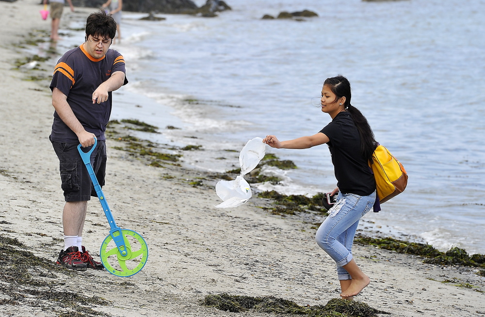 Zach Michaud, left, a second-year SMCC computer science student, is helped by Deering High School graduate Jazmine Abasta as they find the exact landing point of a one-gallon, water-filled projectile.
