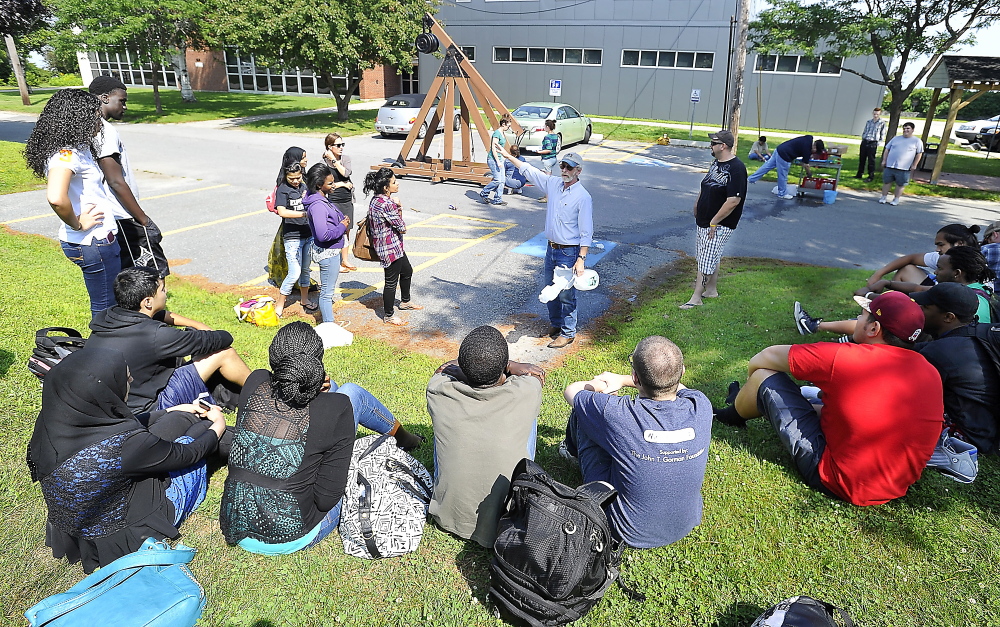 SOUTH PORTLAND, ME - AUGUST 4: With the catapult device called a trebuchet in the background, Associated Professor Kevin D. Kimball explains the details of the physics exercise to the students as Portland and Deering high school students participate in a summer prep course at SMCC and complete it by participating in a physics project involving a trebuchet. (Gordon Chibroski/Staff Photographer)