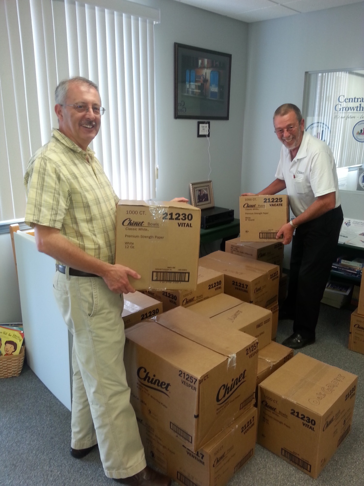 Taste of Waterville volunteers Gary Poulin of EZ to Use.com and Bart Stevens of Century 21 Nason Realty sort boxes containing thousands of biodegradable plates donated by Huhtamaki for the 22nd annual event Tuesday. The event this year is increasing focus on locally grown food and recycling.