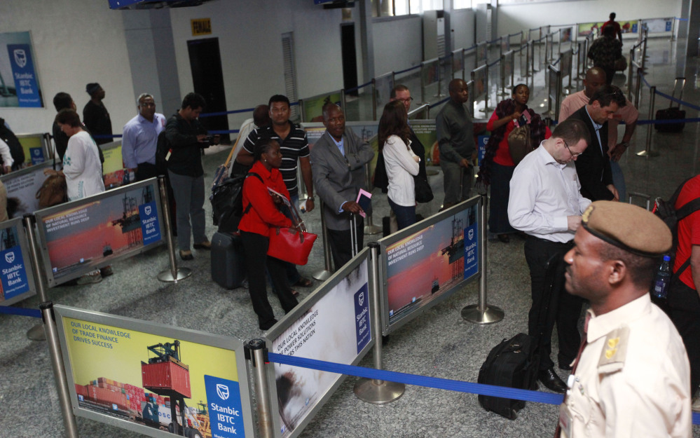 Passengers queue for their passport document check by immigration officers at the arrivals hall of Murtala Muhammed International Airport in Lagos, Nigeria, Monday.
