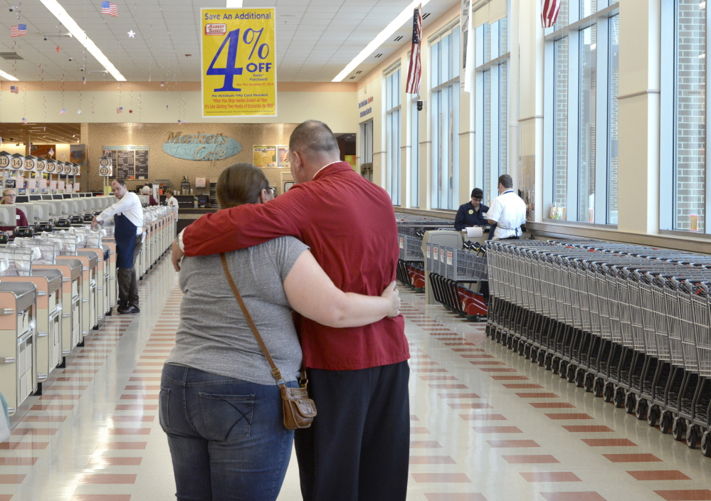 A supervisor, in red coat, comforts a part-time worker who learned Thursday that her hours were being reduced or eliminated at the Market Basket in Biddeford. “Customers just stopped coming in. If there’s no one in the store, we’re not able to use part-timers,” said Micum McIntire, the store manager.