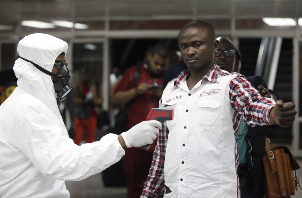 A Nigerian port health official uses a thermometer on a worker at the arrivals hall of Murtala Muhammed International Airport in Lagos, Nigeria, on Wednesday.