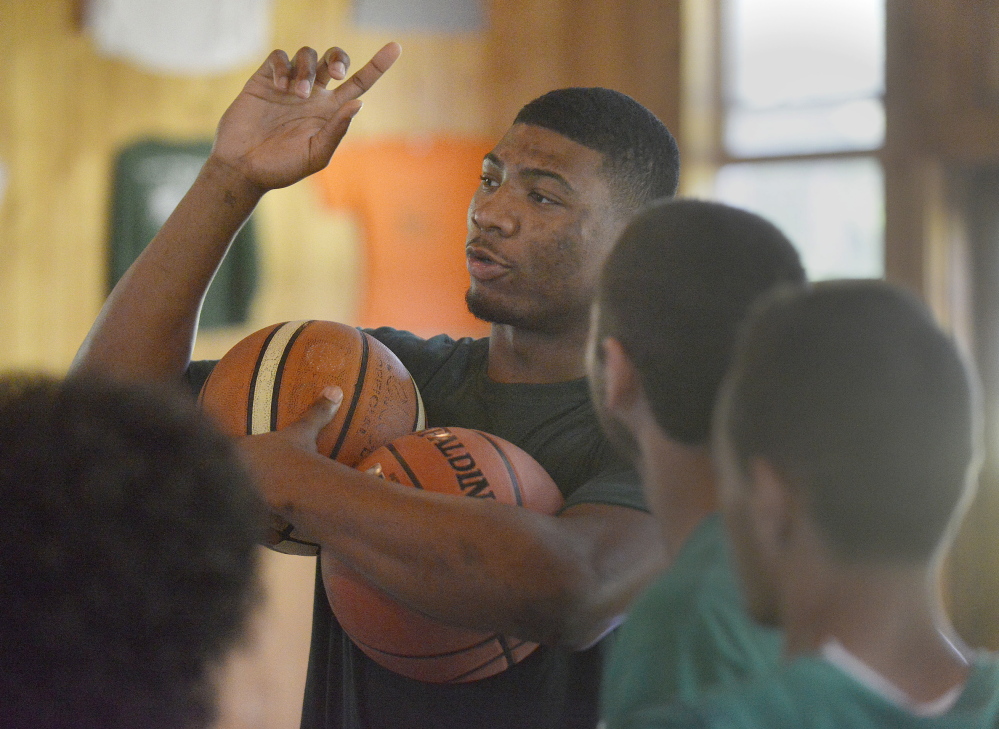 Portland Press Herald photo by John Ewing
NBA basketball players including Boston Celtic first round pick Marcus Smart, participated in the Seeds of Peace’s annual Play of Peace program at the Otisfield summer camp. Smart instucts some of the participating campers in how to do a ball handling drill.