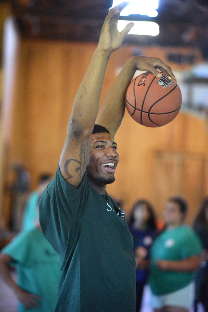 Portland Press Herald photo by John Ewing
Marcus Smart celebrates a camper’s basket while running a layup drill at the clinic.
