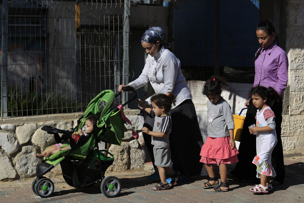 Israeli people flee from an area after a rocket fired from Gaza hit in a residential neighborhood of the southern city of Sderot, Israel, Friday.