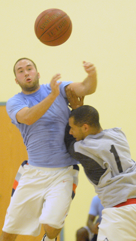 Josh Berard, right, blocks Jay Dangler during a summer league basketball game Wednesday at the YMCA in Augusta.