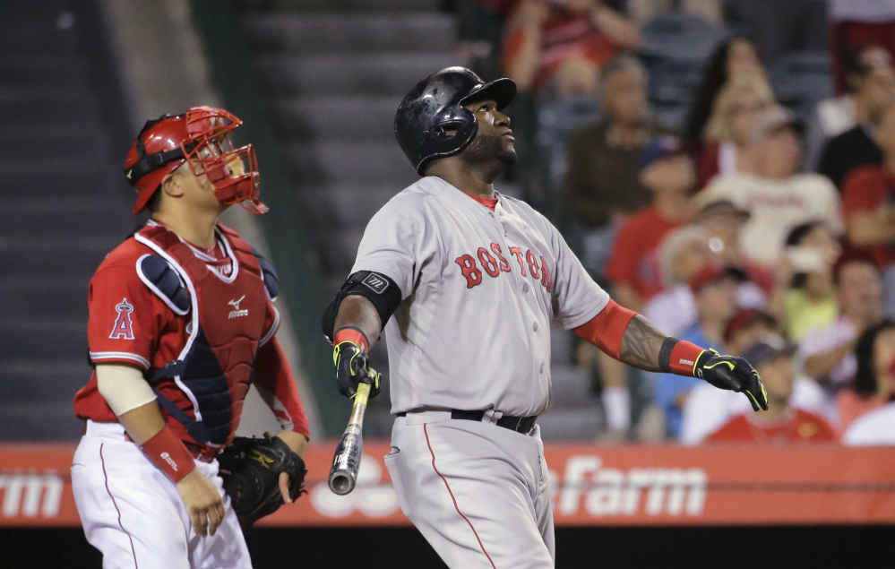 Boston Red Sox’s David Ortiz, center, and Los Angeles Angels catcher Hank Conger watch the flight of Ortiz’s sacrifice fly that scored Dustin Pedroia during the 14th inning of a baseball game on Saturday in Anaheim, Calif.