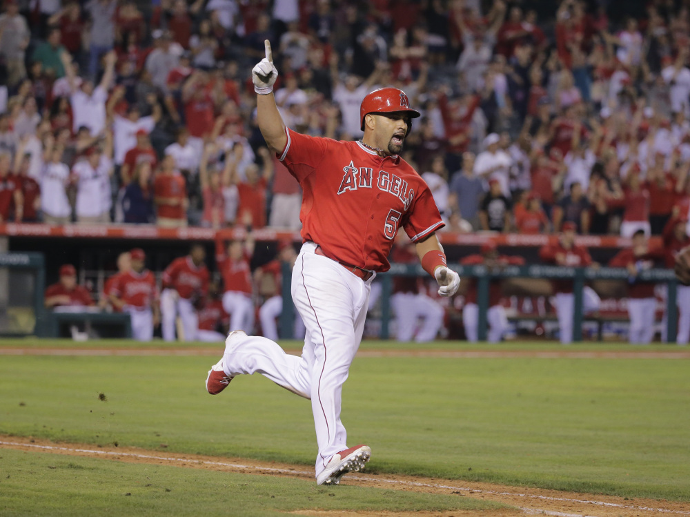 Los Angeles Angels’ Albert Pujols celebrates his walk-off home run during the 19th inning of a baseball game against the Boston Red Sox on Sunday, in Anaheim, Calif. The Angels won 5-4.