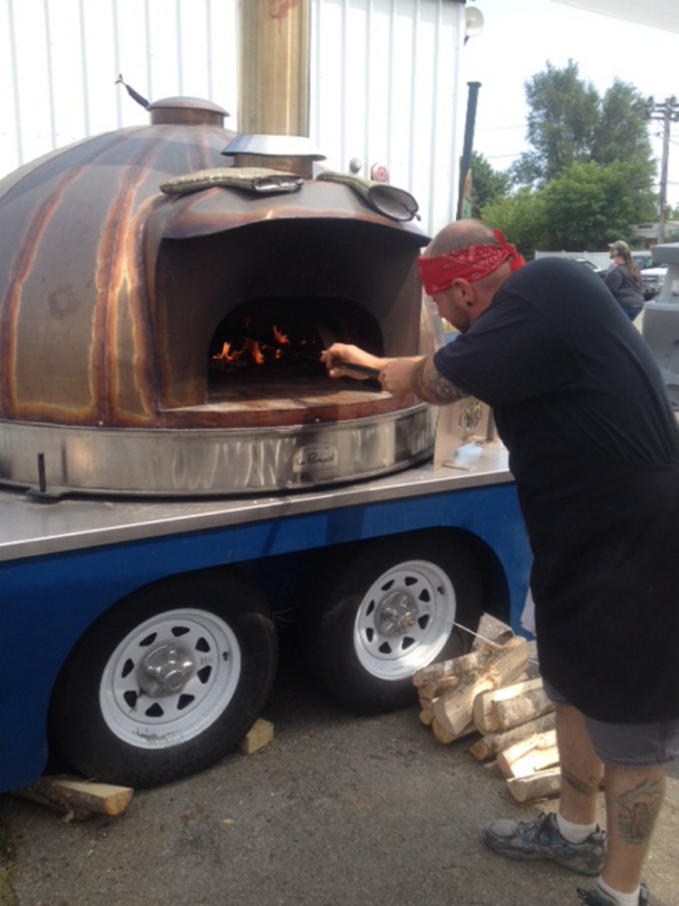 Erik J. LeVine, of Skowhegan, bakes a pizza in a wood fired oven Sunday during the 196th annual Skowhegan State Fair.