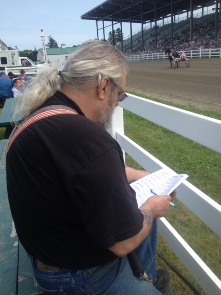 Lawrence Murray, of Fairfield, marks his bet during harness racing Sunday during the 196th annual Skowhegan State Fair.