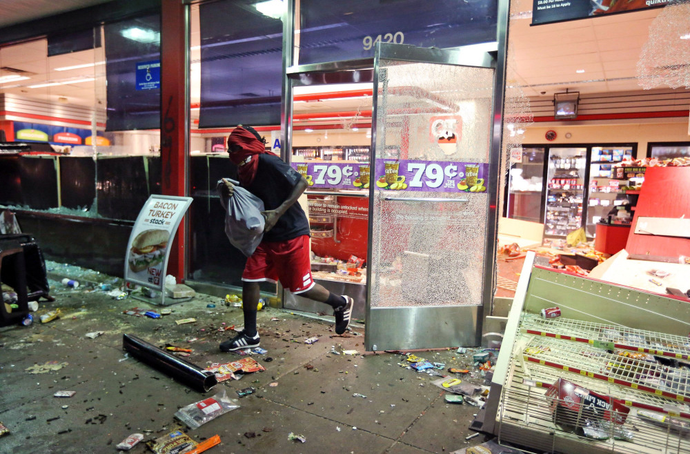 The Associated Press
A man leaves a store on Sunday, in Ferguson, Mo.
