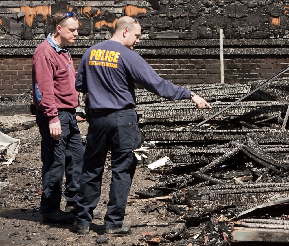 Investigators comb through the rubble of a Lewiston fire that started on May 3, 2013. The fire destroyed four apartment buildings on Bartlett and Pierce streets.