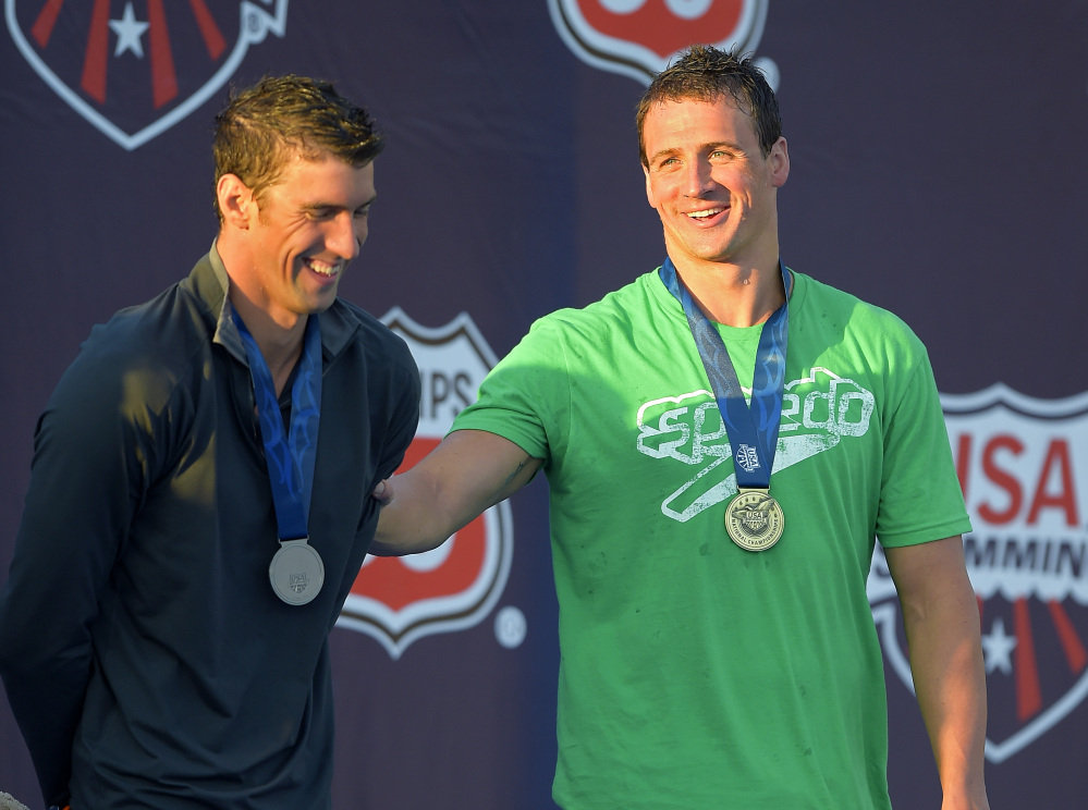 Ryan Lockte, right, jokes around with Michael Phelps during the medals ceremony in the men’s 200-meter individual medley final at the U.S. nationals of swimming, Sunday, in Irvine, Calif.